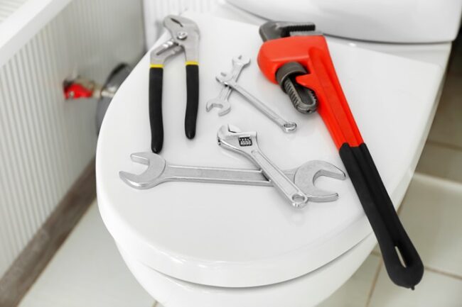 Plumber’s tools on toilet seat lid
